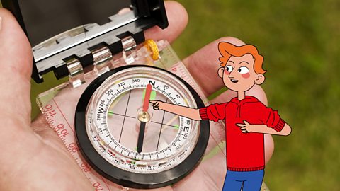 James is pointing at the red needle of a compass to show where north is