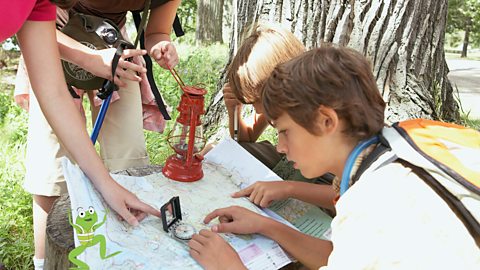 Children are using a compass to work out directions