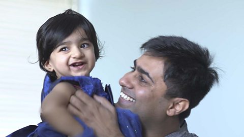 A dad and his daughter laughing.