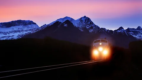 File image of a train travelling past mountains are dawn