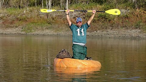 Rick Swenson standing in his pumpkin paddle boat