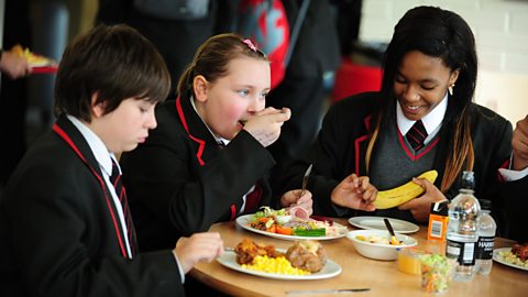 Three secondary school pupils in school canteen