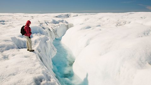 An explorer standing on an ice sheet in Greenland