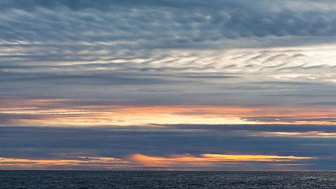 A bank of stratus clouds hang over the sea in the evening