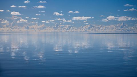 Clouds over a still sea.