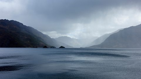 Heavy rain falls into a loch.