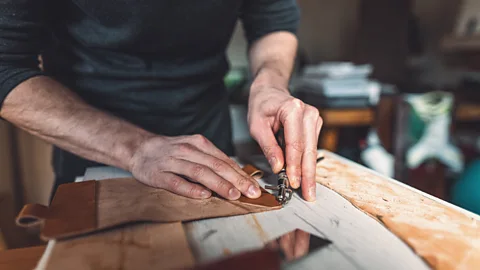 A man making leather purse