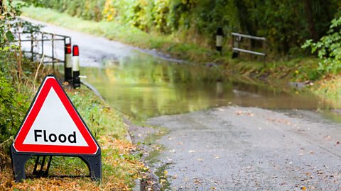 Flooded country road with a flood road sign 