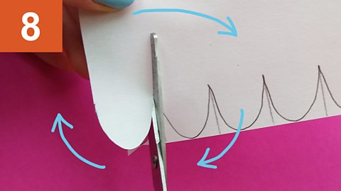 Step 8: Hand rotates a piece of paper as scissors cut along a curve line