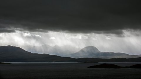 A dark and rainy sky over mountains