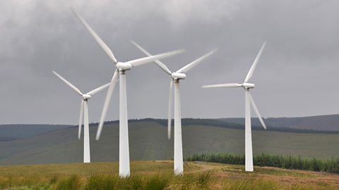 4 wind turbines on top of a hill