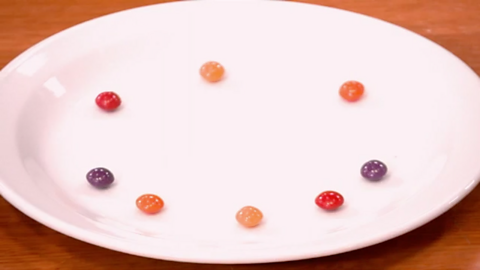 Red, orange and purple sweets on a plate. 