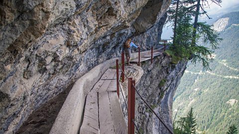 A hiker on the Bisse du Rho trail, Switzerland