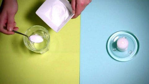 Teaspoon of bicarbonate of soda being added to vinegar