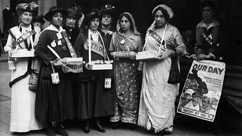 Sophia Duleep Singh standing alongside a group of fellow suffragettes, who are wearing sashes that say 'India'. 