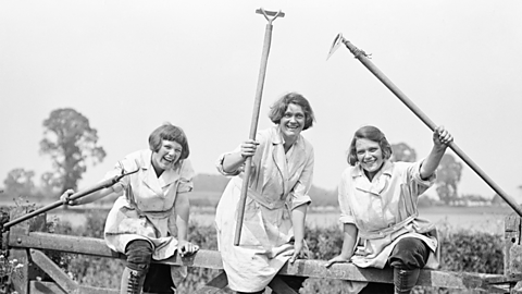 Members of the Women's Land Army pose with their tools.