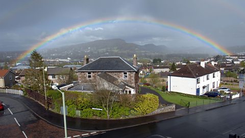 A rainbow going over houses