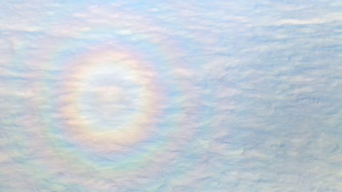 A circular rainbow against a backdrop of clouds.