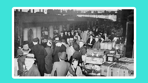 A photograph of people boarding a train while some wait on the platform with luggage, taken about 1937.