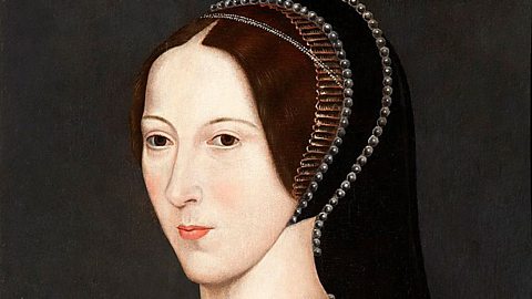 A portrait of Anne Boleyn, who is wearing a black headdress trimmed with pearls. 