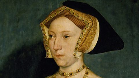 A portrait of Jane Seymour, who is wearing a black and gold headdress and a gold necklace.