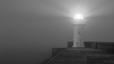 A lighthouse shines its light at night