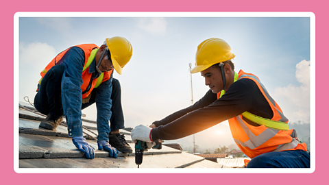 Two builders repairing a roof.