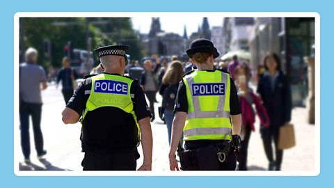 Two police officers walking down the street