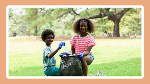 Two children picking up litter. 