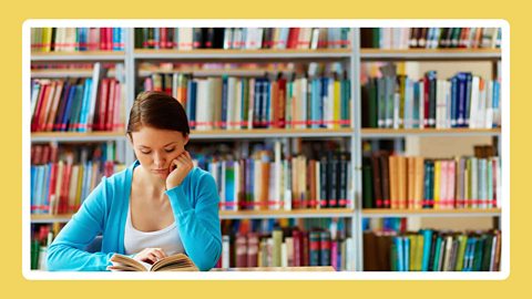 A young woman reading in a public library.