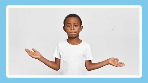 A boy shrugging his shoulders and looking confused.