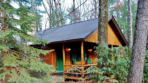 An image of an isolated log cabin in a forest