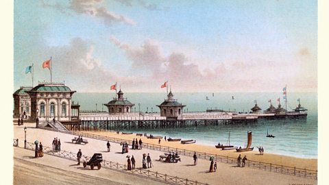 An old postcard showing Brighton West Pier at the seaside.