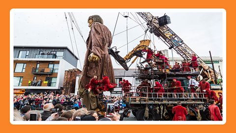 Liverpool Giant float with a giant man and many spectators watching the parade.