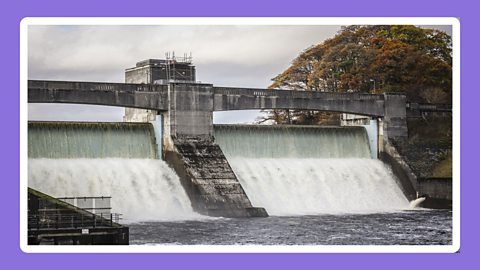 Dam wall with water flowing.