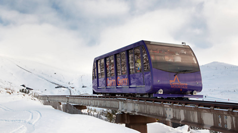 Funicular railway passing through snowy landscape in Aviemore