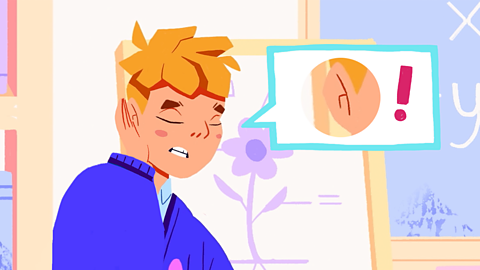 Filip holds his ear in pain. His speech bubble has an ear and an exclamation mark in it