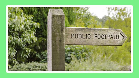 An image of a beautiful wooden 'public footpath' sign on a leafy backdrop