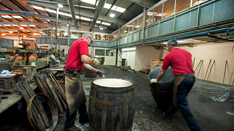 Two employees working on whisky barrells in Speyside Cooperage