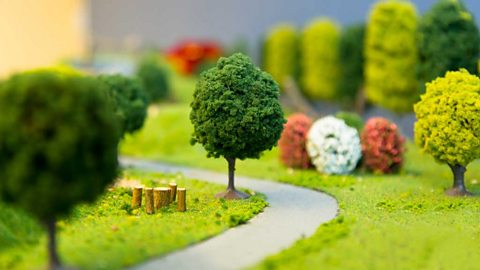 Closeup photograph of a model park with trees, grass and a path