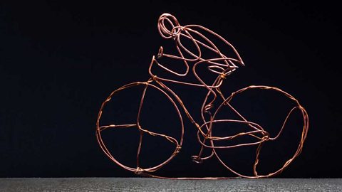 Copper wire sculpture of a figure riding a bicycle