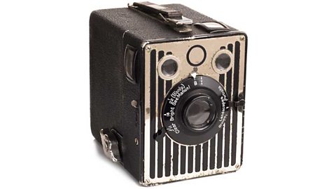 An old box-shaped Kodak camera with a prominent dial on its face