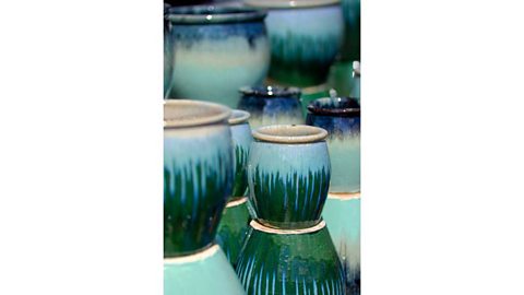 A collection of stacked pots with blue and green glaze