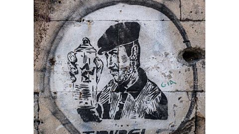 Stencilled spray-painting of a man in a cloth cap holding a spray can