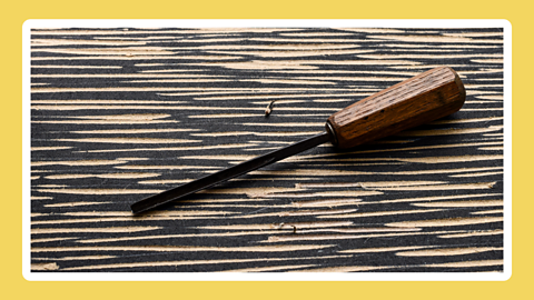 A woodcutting tool on a background of wood with lines cut into it.