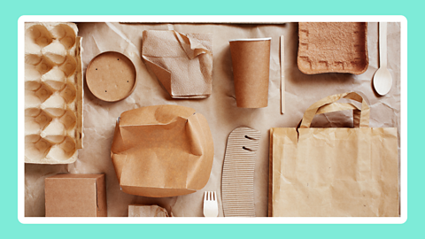 A paper background featuring a range of recyclable items including a paper cup, paper bag, egg box and wooden fork