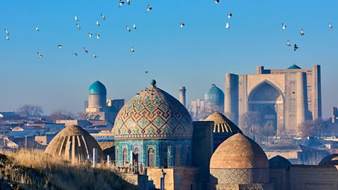 A photo towards the Shah-i-Zinda mausoleum in north-eastern Samarkand, Uzbekistan, displaying geometric patterns and bright colours.