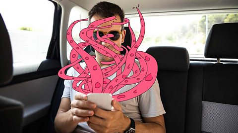 Photograph of a man holding his phone with pink cartoon tentacles coming out of the screen