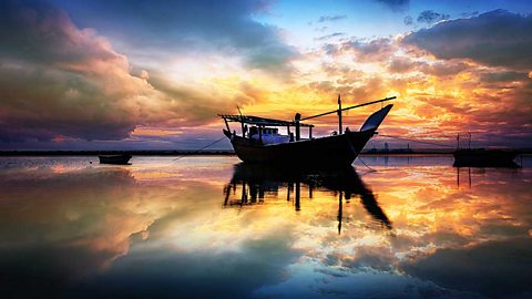 An old fashioned boat on still water in twilight