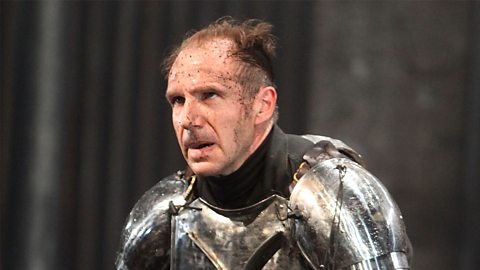 Richard stands with an angry expression on his face. He is wearing heavy silver armour